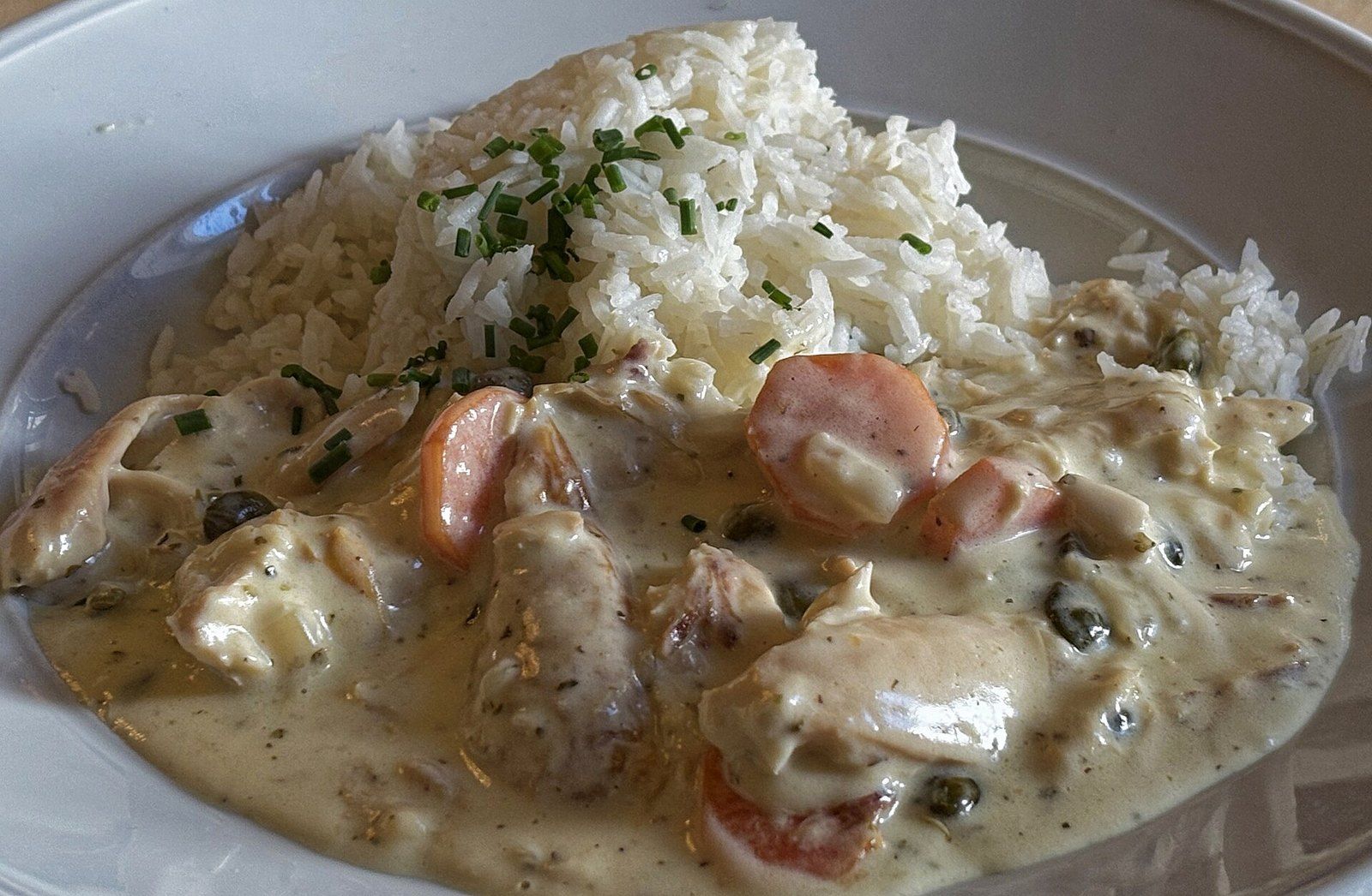 Кусочки курицы в сливочном соусе с морковью и рисом
