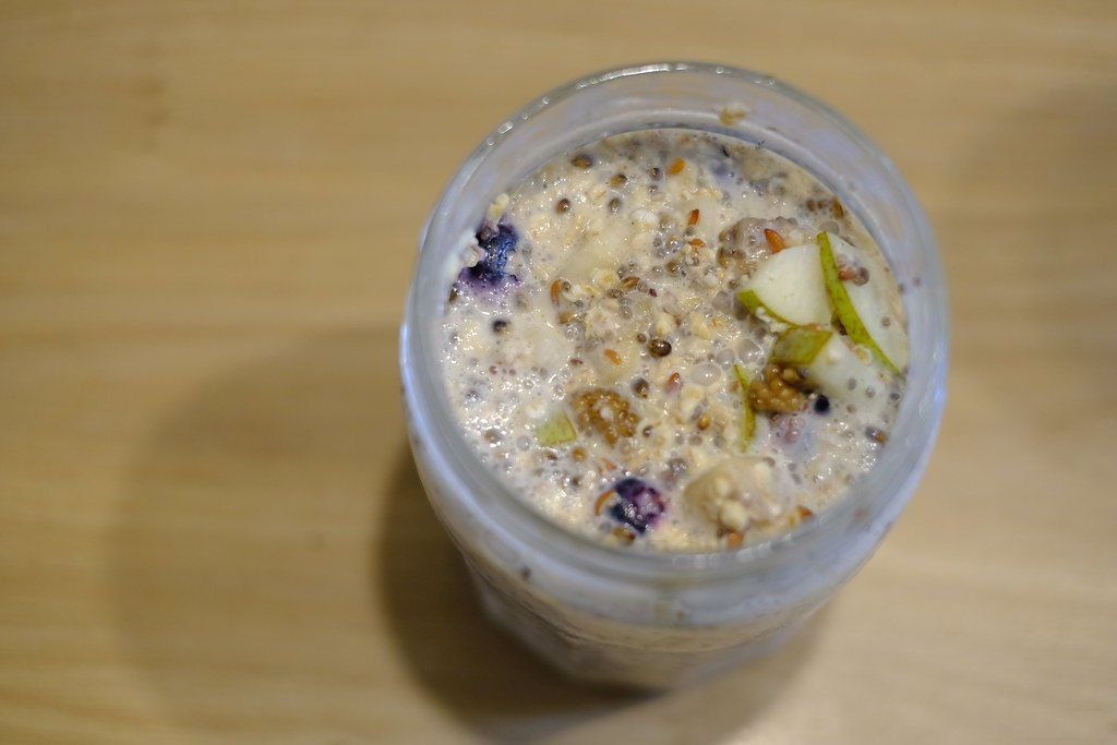Ленивая овсянка с семенами чиа, черникой и кусочками груши в стеклянной банке