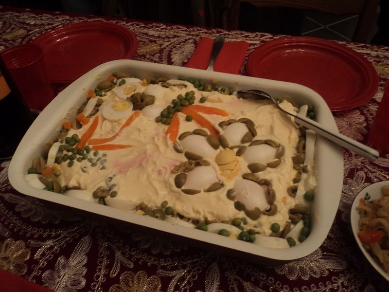 Салат оливье, украшенный горошком и морковью, в прямоугольной форме