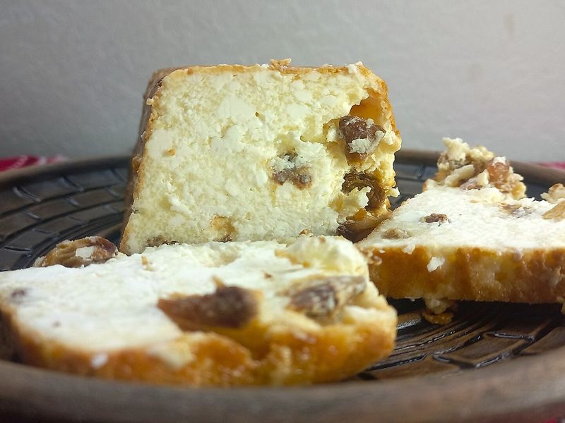Ломти творожной запеканки с изюмом и румяной корочкой на глиняной тарелке